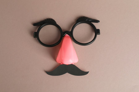 Funny mask with fake mustache, nose and glasses on gray background, top viewの写真素材
