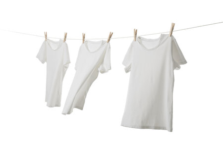 Many t-shirts drying on washing line isolated on whiteの写真素材
