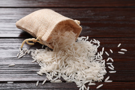 Raw basmati rice and bag on wooden tableの写真素材