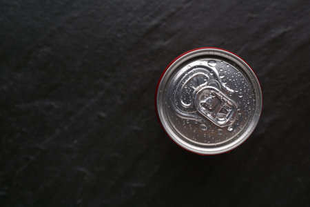 Energy drink in wet can on black textured background, top view. Space for textの写真素材
