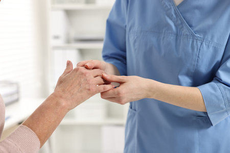 Arthritis symptoms. Doctor examining patient's hand in hospital, closeupの写真素材