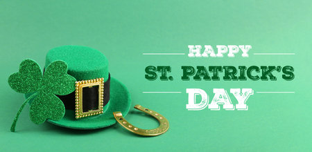 Happy St. Patrick's day card. Leprechaun hat, golden horseshoe, text and clover leaf on green background. Banner designの写真素材