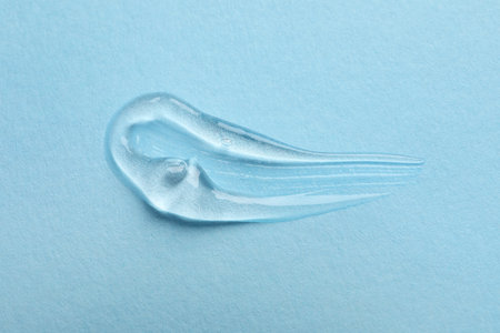 Swatch of cosmetic gel on light blue background, top view