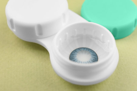 Case with blue contact lenses on light green background, closeupの写真素材