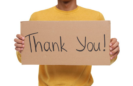 Man holding cardboard sheet with phrase Thank You on white background, closeupの写真素材
