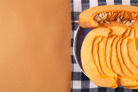 Slices of fresh ripe pumpkin on orange background, top view. Space for textの写真素材