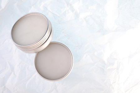 Lip balms on white crumpled paper, top view. Space for textの写真素材