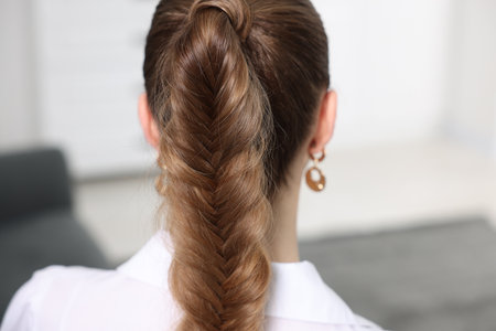Woman with braided hair at home, back view