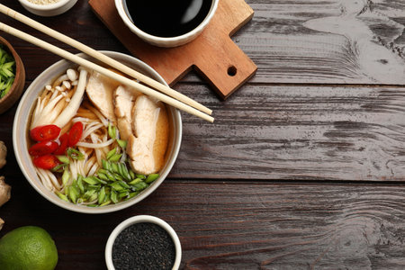 Delicious ramen with meat and ingredients on wooden table, flat lay. Space for textの写真素材