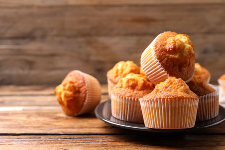 Delicious sweet muffins on wooden table, closeup. Space for textの写真素材