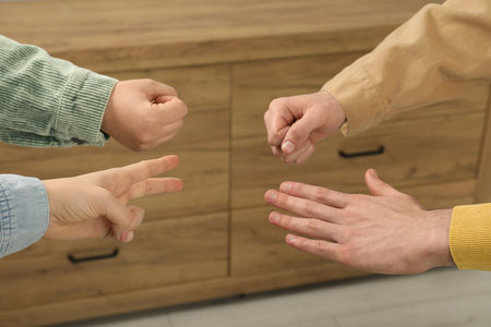 People playing rock, paper and scissors indoors, closeupの写真素材