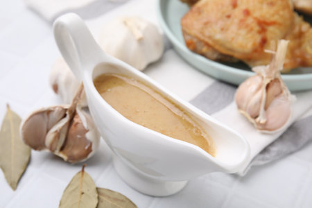 Delicious turkey gravy in sauce boat on white table, closeupの写真素材