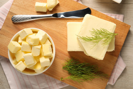 Tasty butter with dill and knife on wooden table, top viewの写真素材