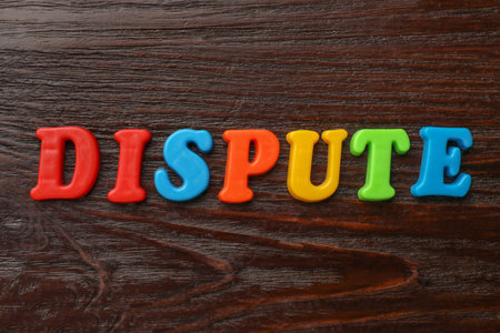 Word Dispute made of colorful letters on dark wooden table, flat layの写真素材