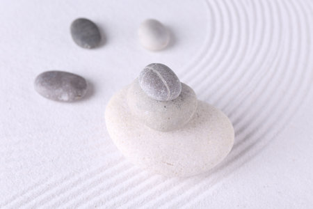 Zen garden stones on white sand with patternの写真素材