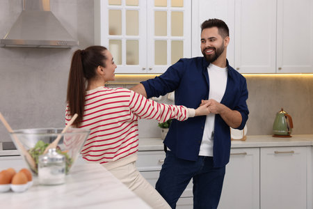 Happy lovely couple dancing together in kitchenの写真素材