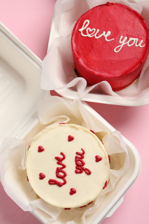 Bento cakes in takeaway boxes on pink table, flat lay. St. Valentine's day surpriseの写真素材