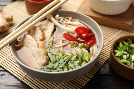 Delicious ramen with meat and ingredients on wooden table, closeup. Noodle soup