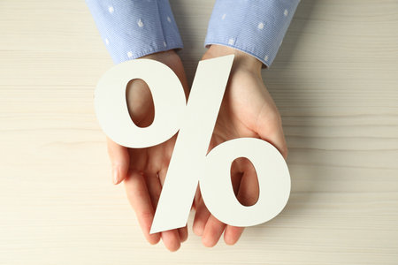 Woman holding percent sign at white wooden table, top viewの写真素材