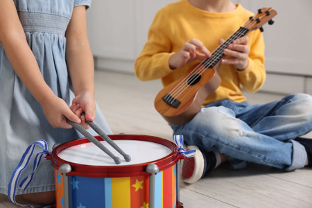 Little children playing toy musical instruments indoors, closeupの写真素材