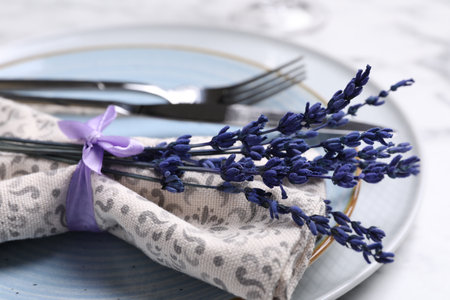 Cutlery, napkin, plates and preserved lavender flowers on table, closeupの写真素材