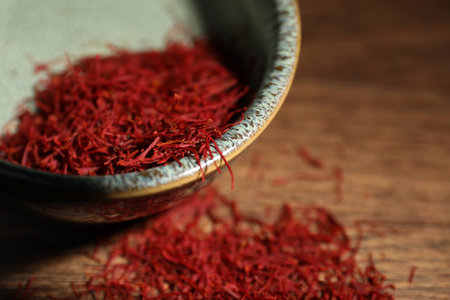 Aromatic saffron in bowl on table, closeup