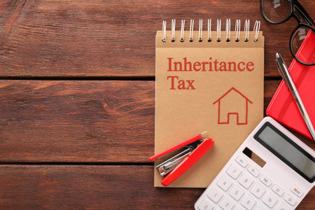 Notepad with phrase Inheritance Tax, stationery and calculator on wooden table, flat lay. Space for textの写真素材