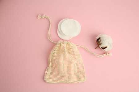 Bag, cotton pads and flower on pink background, flat layの写真素材