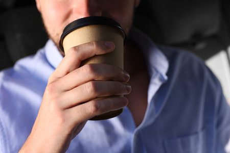 To-go drink. Man drinking coffee in car, closeupの写真素材