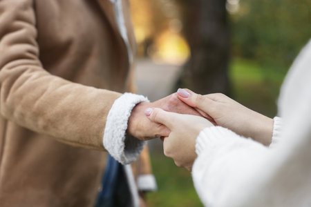 Trust and support. Women joining hands outdoors, closeup