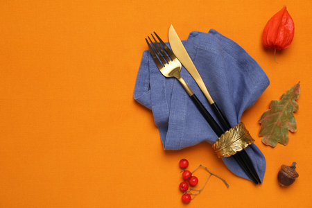 Flat lay composition with cutlery and napkin on orange tablecloth, space for text. Table settingの写真素材