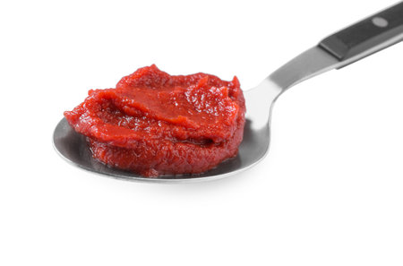 Spoon of tasty tomato paste isolated on whiteの写真素材