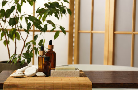 Wooden tray with spa products and stones on bath tub in bathroom. Space for textの写真素材