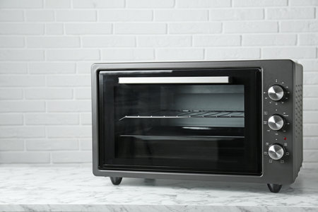 One electric oven on white marble table near brick wallの写真素材