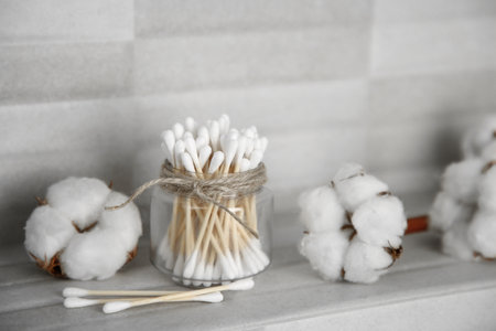 Cotton swabs and flowers on tiled surface indoorsの写真素材