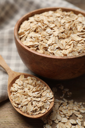 Bowl and spoon with oatmeal on wooden table, closeupの写真素材
