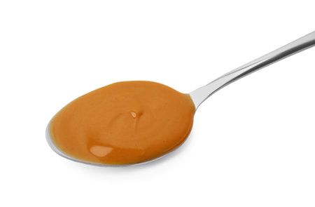 Spoon with tasty peanut butter isolated on whiteの写真素材