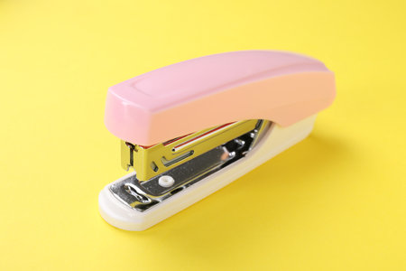 One pink stapler on yellow background, closeupの写真素材