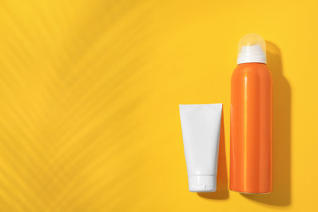 Sunscreens on yellow background, flat lay and space for text. Sun protection careの写真素材