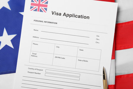 Immigration to USA. Visa application form and pen on flag, flat layの写真素材