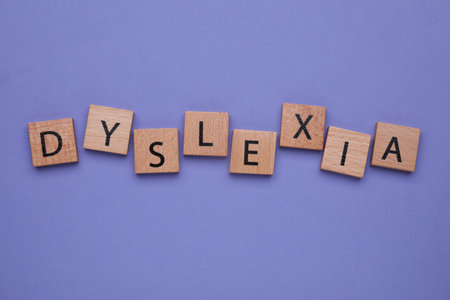 Wooden cubes with word Dyslexia on violet background, flat layの写真素材