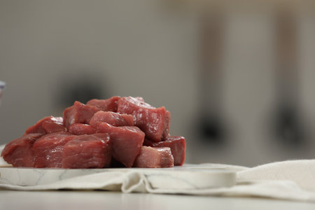 Pieces of raw beef on table against blurred background, closeup. Space for textの写真素材