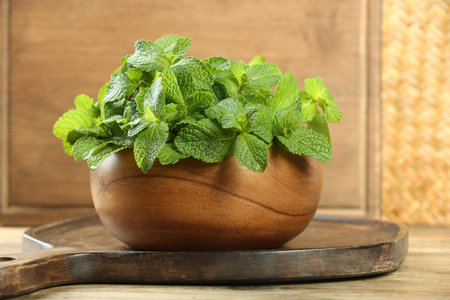 Bowl with fresh green mint leaves on wooden tableの写真素材
