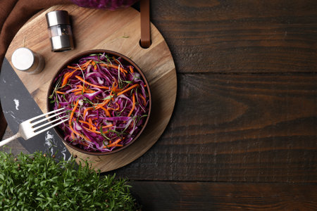 Eating tasty salad with red cabbage on wooden table, flat lay. Space for textの写真素材