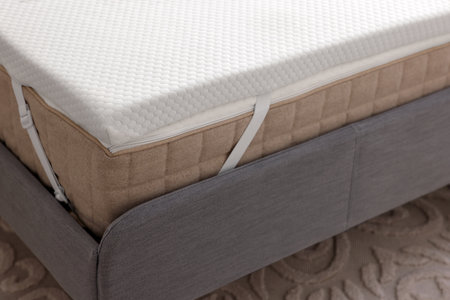 White memory foam mattress topper on gray bed