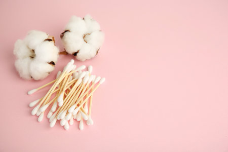 Many cotton buds and flowers on pink background. Space for textの写真素材