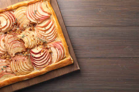 Freshly baked apple pie with nuts on wooden table, top view. Space for textの写真素材