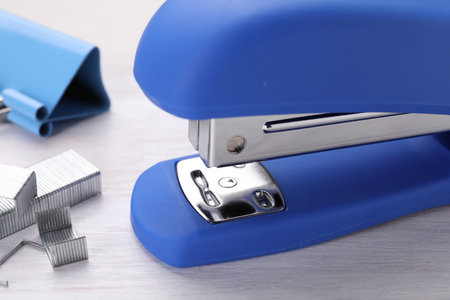 Blue stapler with staples on light wooden table, closeupの写真素材