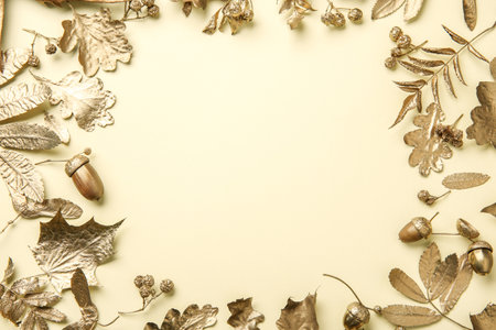 Frame made of different golden leaves on beige background, flat lay with space for text. Autumn...
