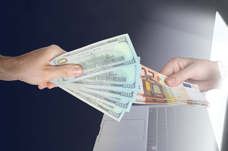 Online money exchange. Woman holding dollars and man giving euro banknotes to her through laptop...